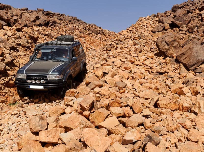 4x4 toyota roulant sur un chemin de pierres dans le désert